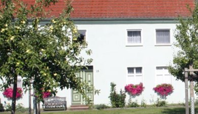 Pension Krüger Wohngebäude mit Blumenkästen und danebenliegender Toreinfahrt